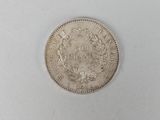 a close up of a silver coin on a white surface