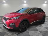 une voiture rouge est garée dans une pièce au sol en damier