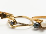 deux bagues en or ornées de perles et de grenats sur un fond blanc