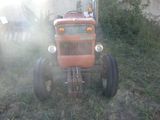 un tracteur rouge assis dans l'herbe