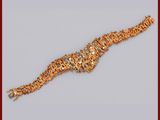 un bracelet en or orné de nombreux petits éléments en or