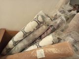 many rolls of fabric sitting in a box on the floor