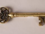 an old key is sitting on top of a white surface