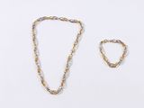 two pieces of gold jewelry on a white surface