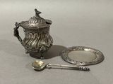 a silver tea pot and a silver plate with a spoon on it