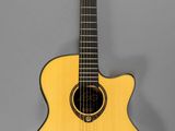 a yellow acoustic guitar on a stand against a gray background