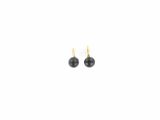 une paire de boucles d'oreilles avec des perles noires sur fond blanc