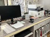 a desk with a computer and a printer on it