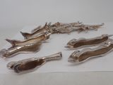 six silver plated spoons and spoon rest on a piece of paper