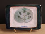 une assiette bleue et verte ornée d'un motif de feuilles