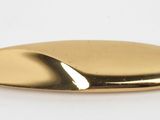a close up of a gold metal object on a white surface