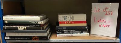 de nombreux livres sur une étagère, avec une pancarte posée dessus