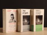 trois livres posés sur une table en bois, l'un à côté de l'autre