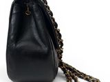 a black purse with a chain hanging from the handle