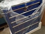 une boîte à outils bleue posée sur un chariot dans un entrepôt