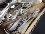 a box full of forks and spoons sitting on a table