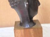 statue of a woman ' s head on a wooden base