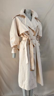 une photo d'un mannequin vêtu d'un trench-coat, posé sur un pied de mannequin