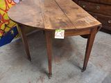 une table en bois sur laquelle se trouve une horloge, dans une pièce