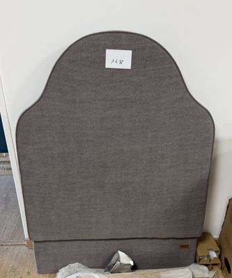 un lit dont la tête de lit est en tissu gris