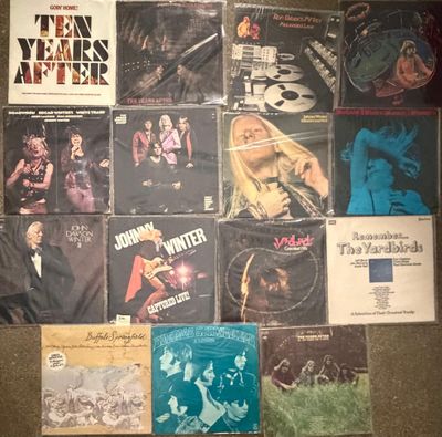 various albums and cds are arranged on the floor of a room