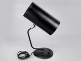une lampe de table noire sur fond blanc, avec un cordon