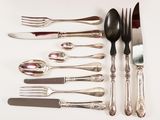 a lot of silverware on a table with spoons and knives