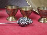 trois coupes en argent et un vase en argent posés sur un tissu rouge
