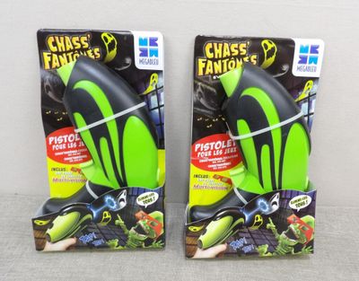 pair of two green and black plastic toys on a white surface