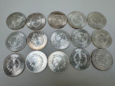 some silver coins are arranged in a row on a white surface