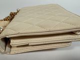 beige purse with chain and chain strap on white background