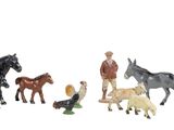 plusieurs figurines représentant des chevaux et un homme accompagné d'un chien dans un champ