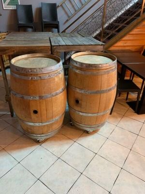 deux tonneaux en bois posés l'un à côté de l'autre sur un sol carrelé