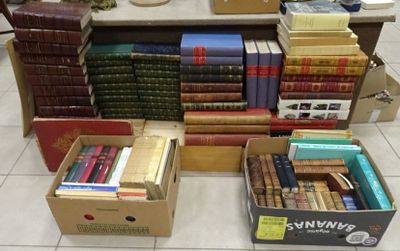 several boxes of books are stacked on a table in a room