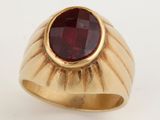 a gold ring with a red stone in the center