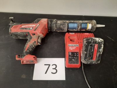 une perceuse filaire et deux batteries posées sur une table