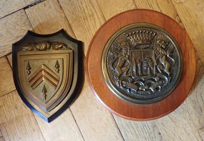 Deux tapes de bouches en bronze sur écu en bois.