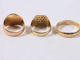 three different types of gold rings on a white surface