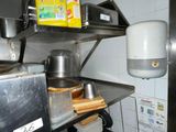 a metal shelf with pots and pans on it in a kitchen