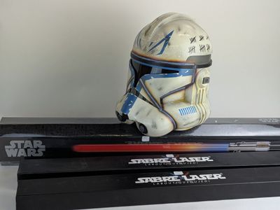 a star wars helmet sitting on top of a stack of star wars books