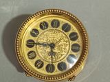 a gold pocket watch with roman numerals on the face