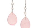 une paire de boucles d'oreilles en verre rose avec des crochets en argent, sur fond blanc