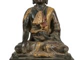 une photo représentant une statue d'une personne assise sur une table