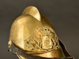 an old fireman ' s helmet on a stand against a black background