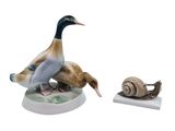 a figurine of a duck and a snail sitting on a table