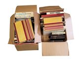 many books in a cardboard box on a white surface
