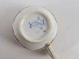 a white cup with blue writing on it sitting on a table