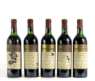 quatre bouteilles de vin sont alignées sur une surface blanche