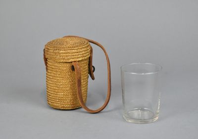 a small wicker bag and a glass on the table