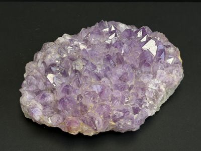 un gros plan d'un rocher recouvert de nombreux cristaux violets